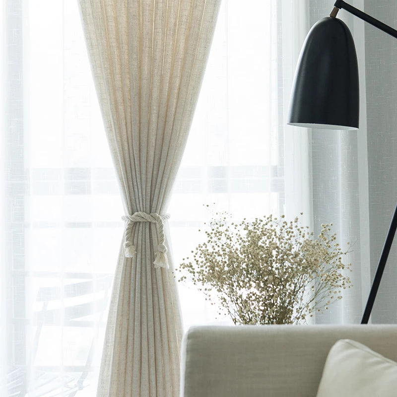 Voilage effet lin naturel noué élégamment au centre, laissant passer la lumière dans un salon lumineux à la décoration épurée.