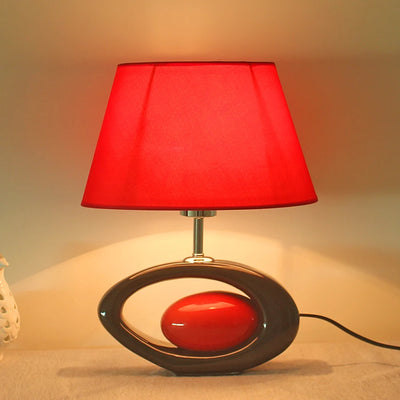 Lampe de chevet dorée en céramique avec abat-jour blanc sur table de nuit