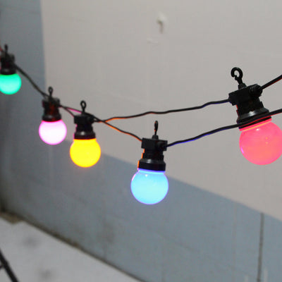 Guirlande lumineuse LED 30 ampoules colorées suspendue dans un jardin
