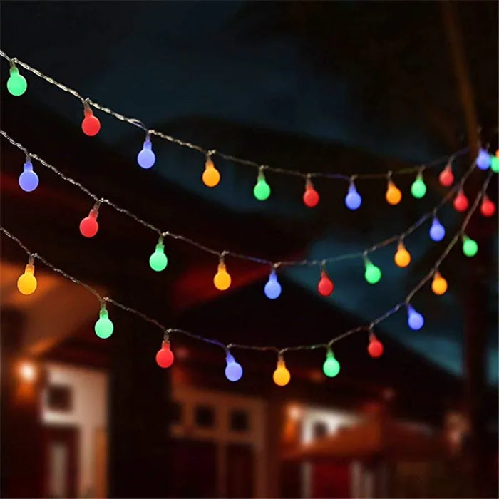 Guirlande lumineuse à boules LED multicolores 10m décorant un jardin