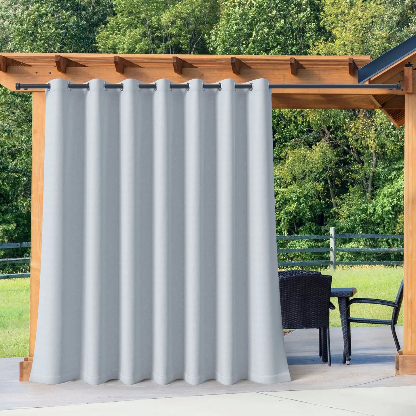 Rideau occultant gris clair suspendu à une structure en bois, parfait pour protéger du soleil et du vent en terrasse.