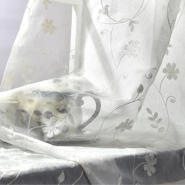 Rideaux blancs en soie avec un motif brodé créatif, inspiré par l'art du textile. Ces rideaux luxueux, rappelant le lin d'une nappe de table ou d'un drap de lit, sont accentués par des détails argentés. Idéal pour apporter une touche d'élégance et de sophistication à tout intérieur.