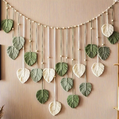 Plume en macramé suspendue abricot sur mur blanc