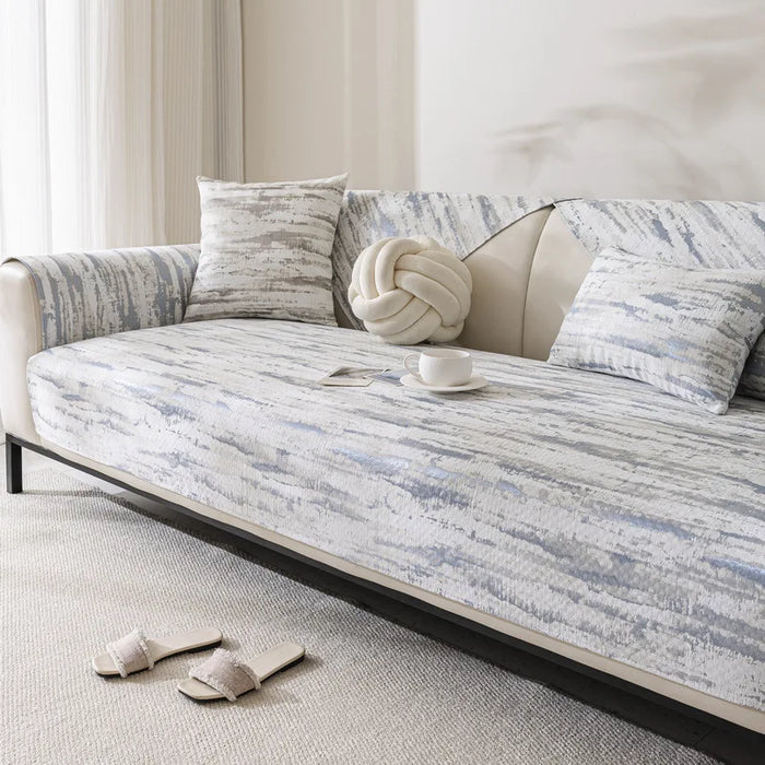 Le canapé rembourré avec des motifs abstraits et des coussins décoratifs offre une atmosphère de détente et de confort dans cette pièce lumineuse.