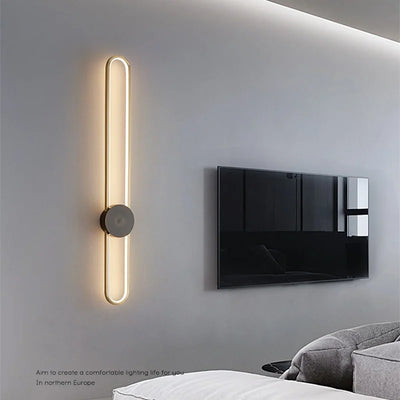 Applique murale LED moderne noire et or allumée dans un salon contemporain