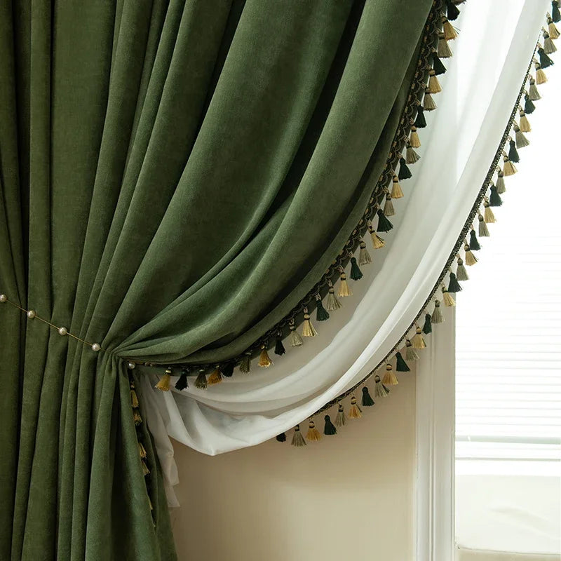 Rideau vert forêt doublé d’un voilage blanc, avec bordure pompons décorative.