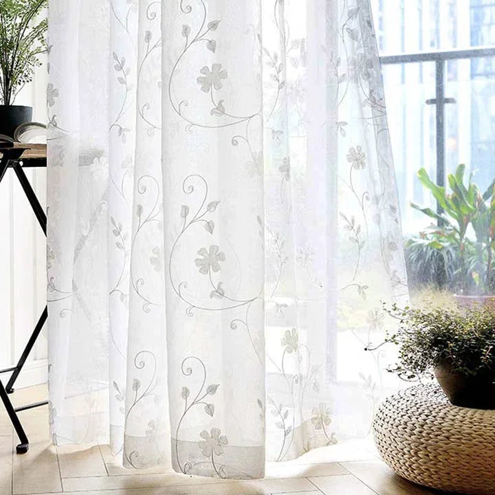 Une élégante conception d'intérieur de salon mettant en vedette un traitement de fenêtre avec des rideaux blancs en textile de haute qualité, accompagné d'accessoires de maison tels qu'une plante d'intérieur luxuriante dans un vase décoratif et de beaux linges de maison. Le design raffiné et l'harmonie des couleurs créent une ambiance apaisante et invitante. Le rideau blanc, principal objet de cette image, ajoute une note de fraîcheur et de luminosité à la pièce.