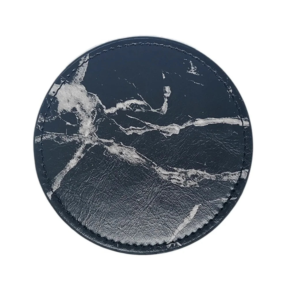 Disque décoratif en marbre noir et gris avec des motifs abstraits et des textures contrastées.