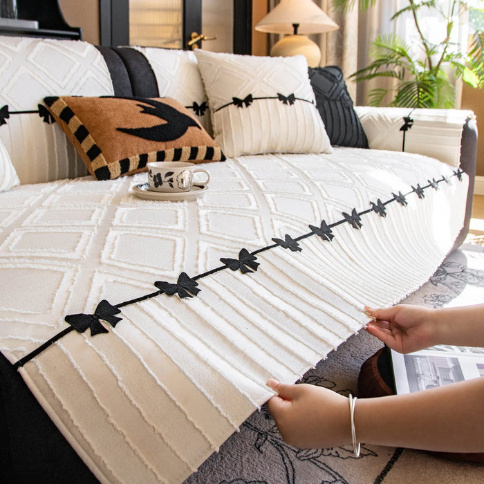 Élégant canapé avec des oreillers décoratifs noirs et blancs dans un cadre verdoyant.