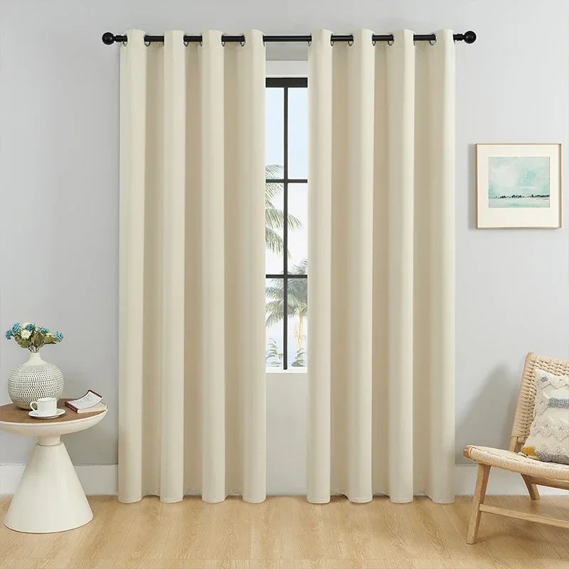 Rideau occultant uni couleur beige, élégant et sobre, idéal pour salon ou chambre, installé sur une tringle noire avec œillets.
