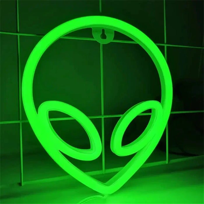 Enseigne au néon extraterrestre verte LED allumée dans une chambre sombre