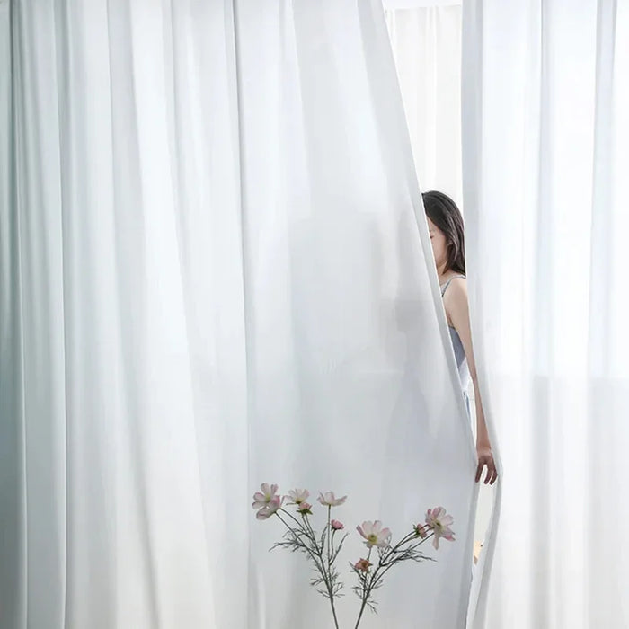 Voile de rideau blanc élégant pour salon moderne, offrant une ambiance lumineuse et délicate. Idéal pour créer un espace intime et épuré dans votre intérieur. Ajoutez une touche de sophistication à votre décoration tout en préservant la luminosité naturelle.