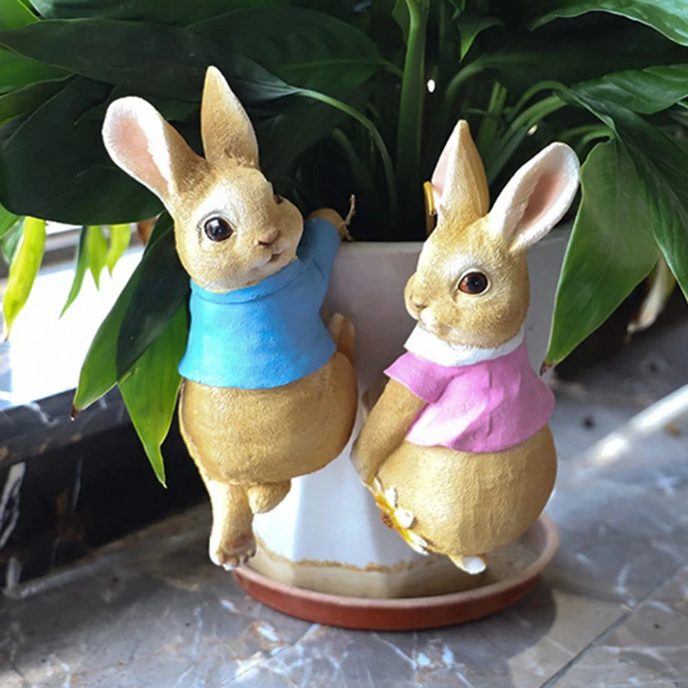 Deux mignons lapins en peluche portant des vêtements colorés, entourés de feuillage verdoyant, offrant une image charmante et printanière.