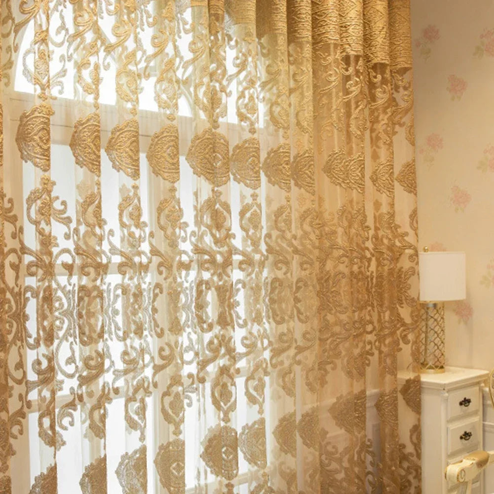Grand voilage doré style oriental couvrant une baie vitrée, filtrant doucement la lumière naturelle dans une chambre raffinée.