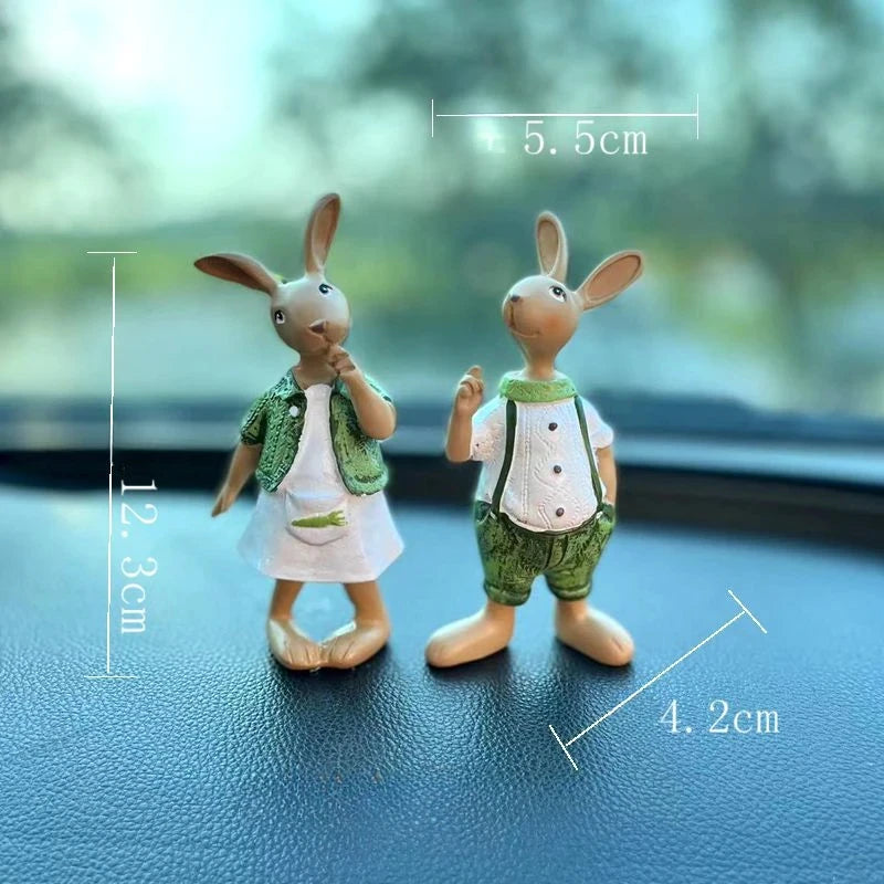 Deux figurines en forme de lapins vêtus de vêtements verts, debout sur une surface sombre avec des dimensions indiquées dans l'image.