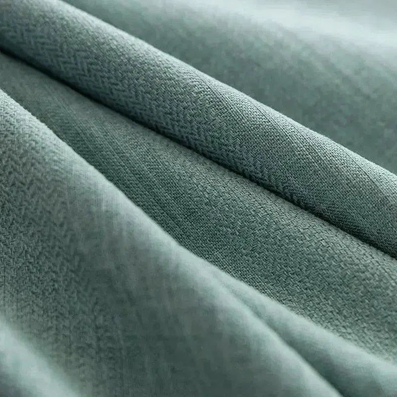 Tissu vert doux en gros plan montrant une texture délicate et élégante, idéal pour la décoration intérieure ou la confection de vêtements raffinés.
