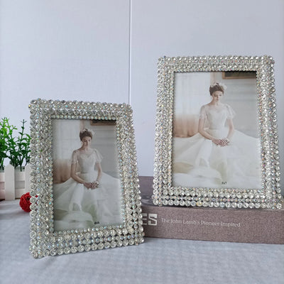 Cadre photo en métal blanc incrusté de diamants brillants sur un bureau moderne