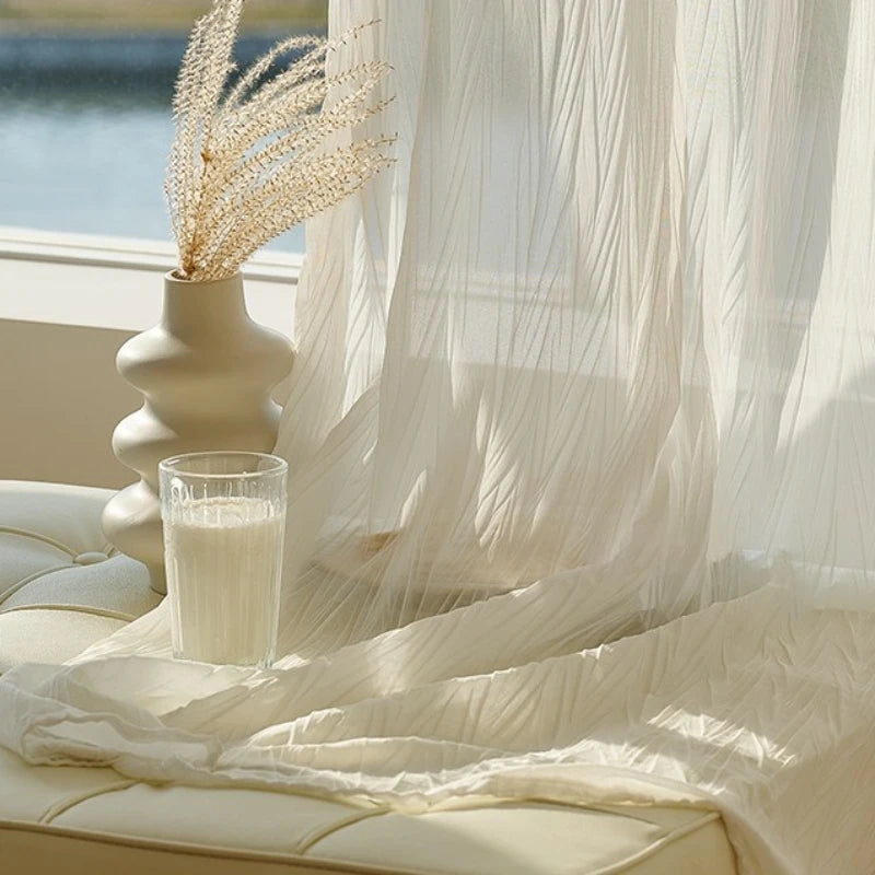Voilage blanc effet froissé devant une fenêtre, accompagné d’un vase design et d’un verre de lait, ambiance douce et apaisante.