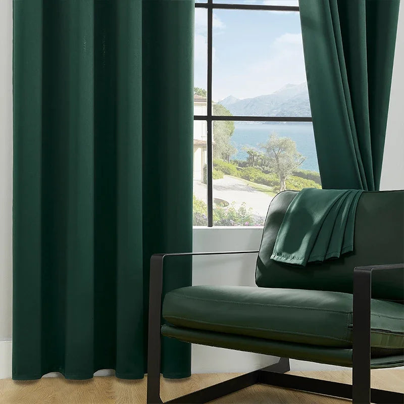 Rideaux en textile de couleur vive suspendus comme traitement de fenêtre dans un salon moderne. Ces rideaux, qui sont un élément essentiel de la décoration de la fenêtre, ajoutent une touche d'élégance tout en offrant une couverture efficace de la fenêtre. À côté, un canapé en cuir ajoute un contraste de texture à la pièce.