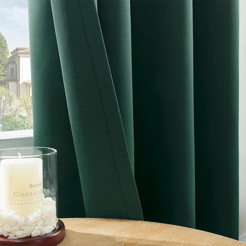 Des rideaux luxueux de couleur verte avec des œillets en métal, suspendus à une fenêtre dans un salon élégamment aménagé, apportant une touche chaleureuse et raffinée à la décoration intérieure. Ces rideaux, fabriqués en textile de haute qualité, sont une solution idéale pour le traitement des fenêtres, ajoutant à la fois style et intimité.