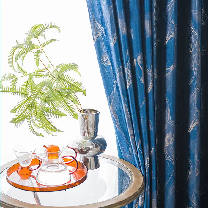 Rideau bleu foncé à motifs modernes avec une table en verre et vase chromé décoratif