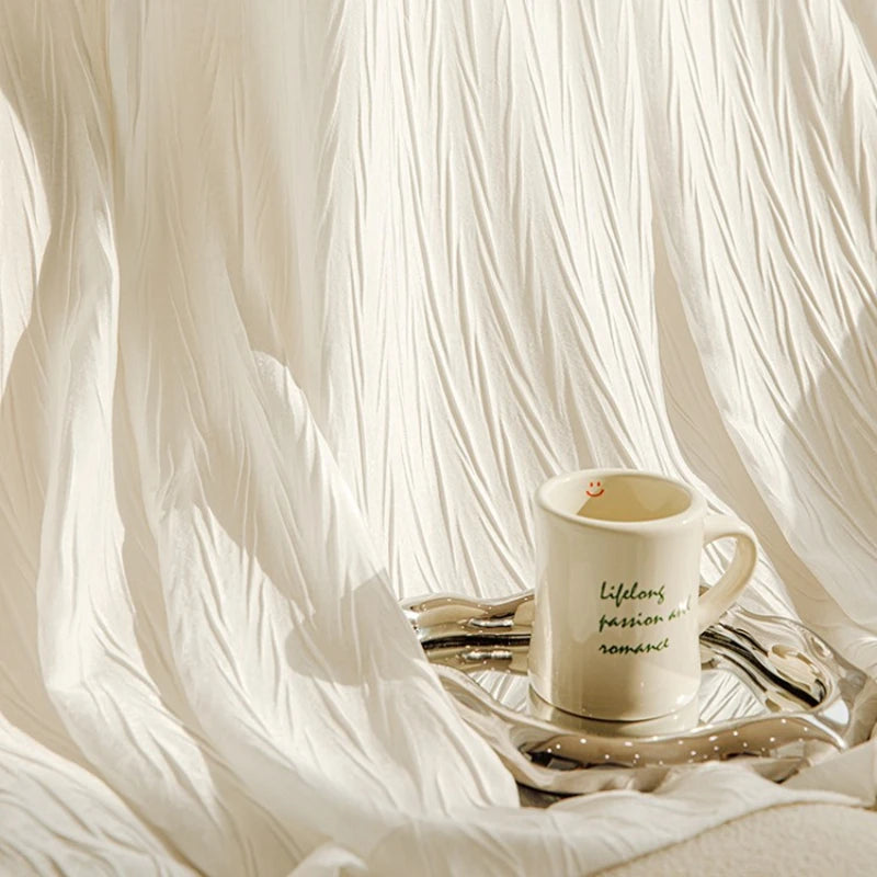 Voilage blanc plissé avec un mug posé sur un plateau, baigné dans une lumière chaude et naturelle.