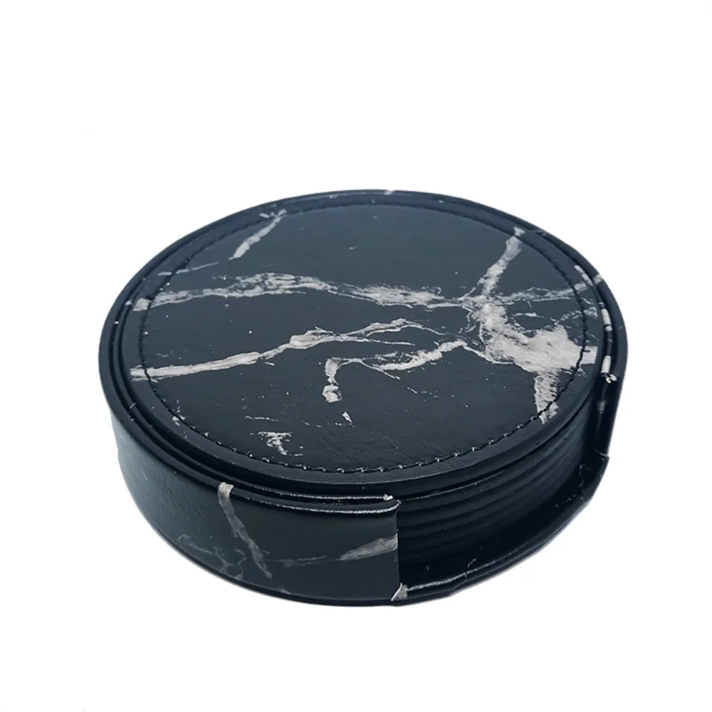 Ensemble rond de sous-verres en ardoise noire avec un motif de marbre blanc.