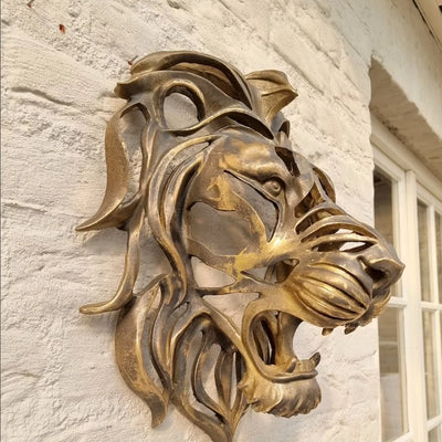 Tête de lion murale en résine dorée vue de face sur fond blanc