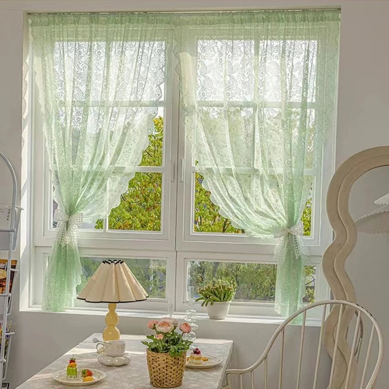 Voilage vert transparent en dentelle, installé sur une fenêtre blanche dans une salle à manger cosy au style vintage fleuri.