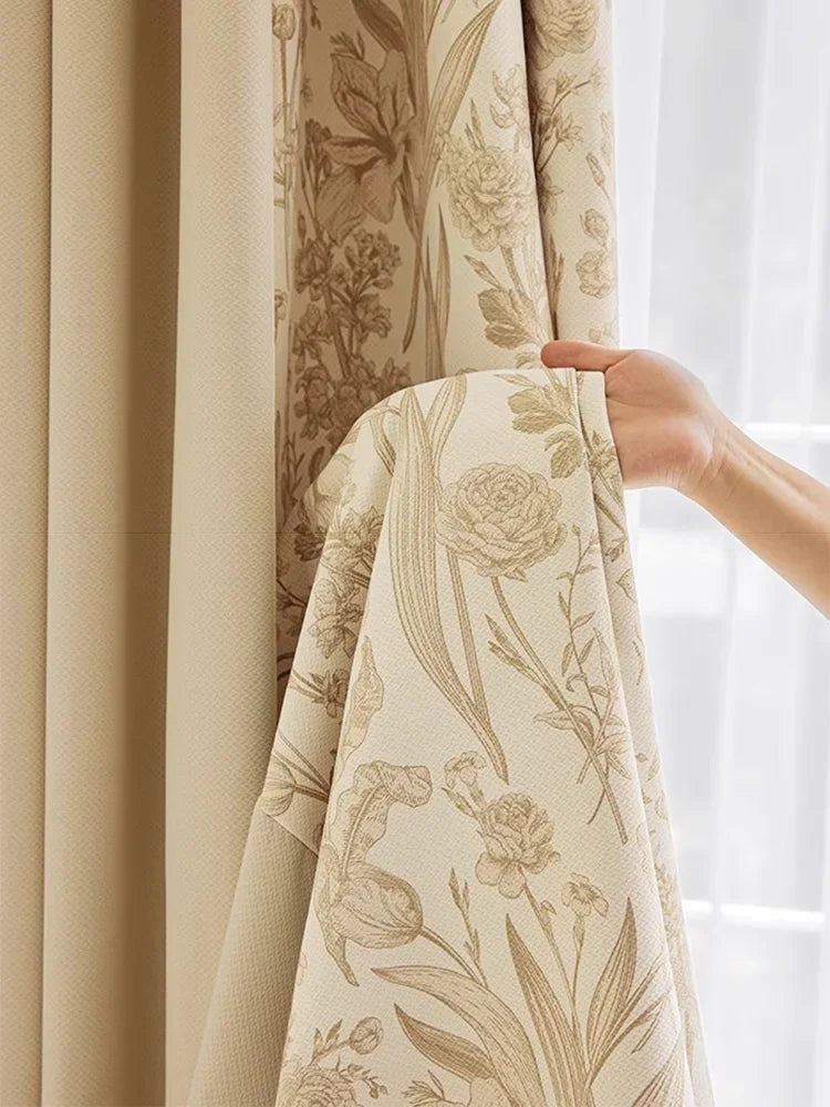 Tissu du rideau crème fleuri tenu à la main, montrant sa texture et sa douceur naturelle