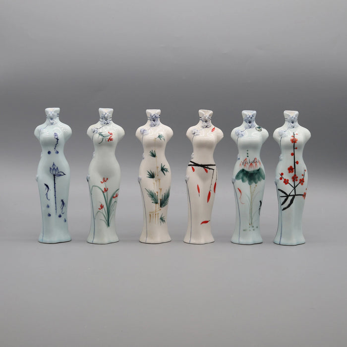 Une série de vases décoratifs en céramique blanche, chacun orné de délicats motifs floraux peints à la main, créant une présentation harmonieuse et élégante.