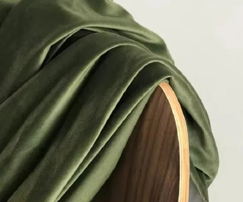 Tissu de rideau occultant kaki vert olive en velours posé sur un fauteuil