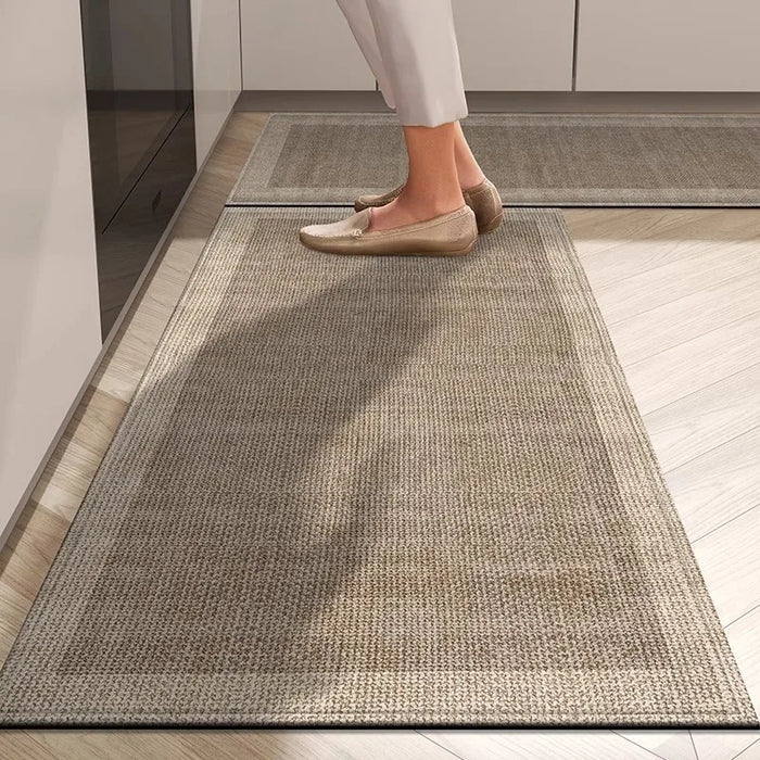Un tapis de couleur grise recouvrant le sol, sur lequel on peut voir des pieds chaussés de mocassins beiges.