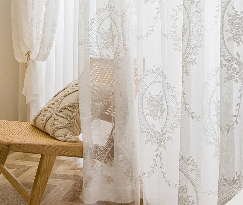 Détail du voilage blanc esprit bord de mer avec broderies florales dans un intérieur chaleureux