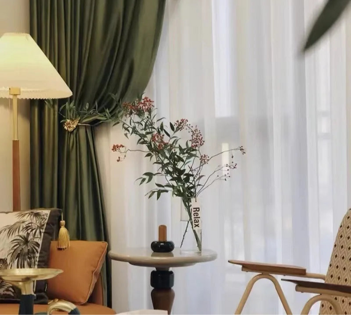 Rideau occultant kaki vert olive installé dans un salon moderne avec voilage blanc
