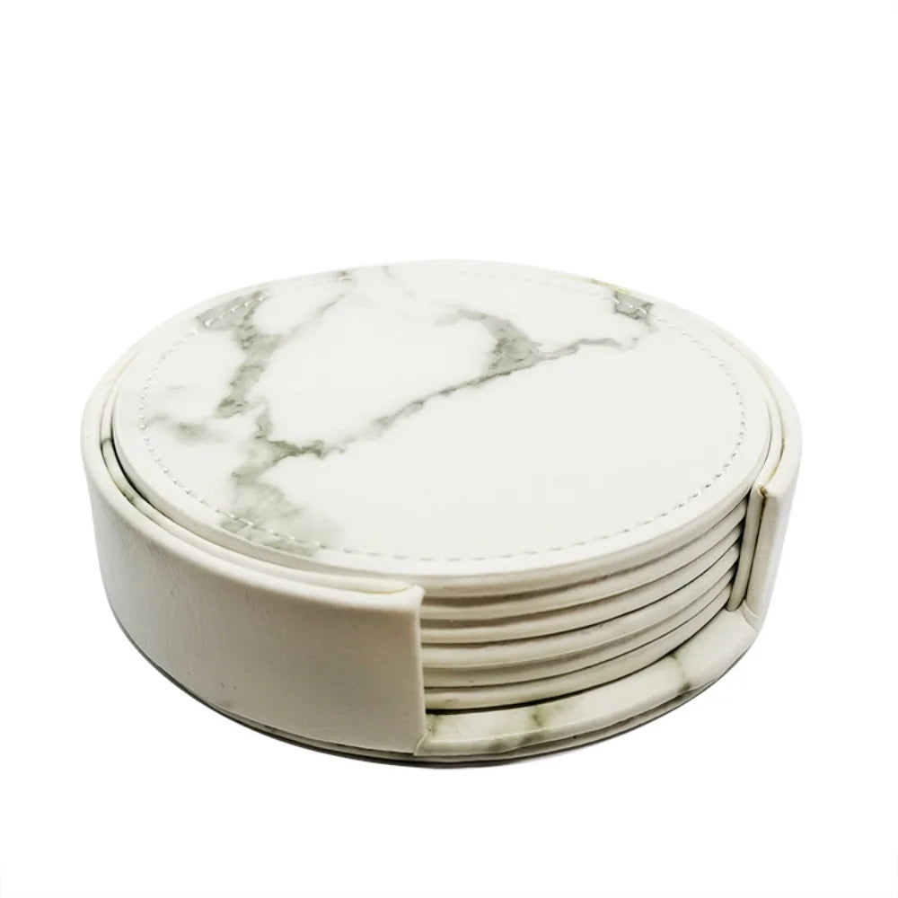 Des sous-verres ronds en marbre blanc avec motifs gris constituent un ensemble élégant et durable pour protéger les surfaces.