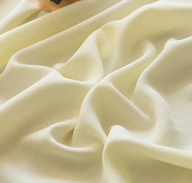 Zoom sur le tissu doux et translucide du voilage jaune clair à ruflette, en polyester, à la texture fluide et lumineuse.