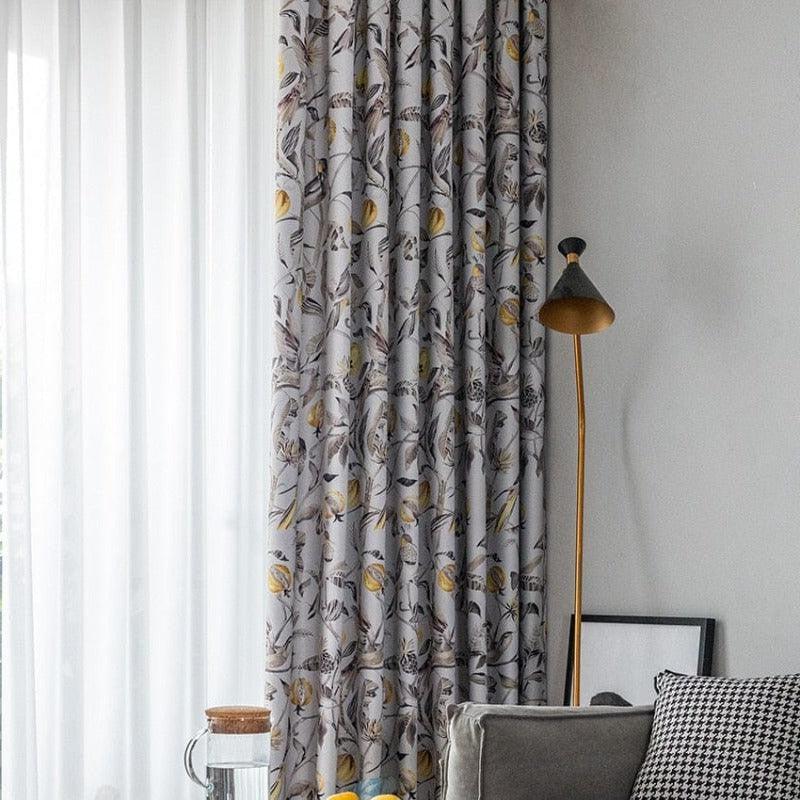 Rideaux élégants à motifs floraux dans un salon moderne, accentuant une décoration intérieure raffinée avec lumière naturelle, lampe design et coussin à motifs géométriques. Améliorez votre espace de vie avec ces rideaux décoratifs et contemporains.
