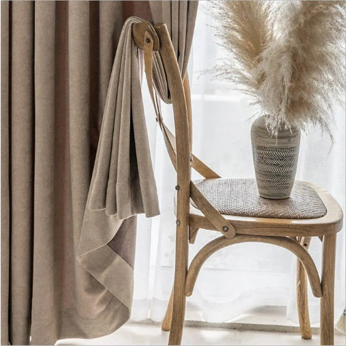 Voilage élégant beige pour intérieur moderne, accroché à une chaise en bois, apportant une ambiance chaleureuse et apaisante à votre décoration d'intérieur. Complété par un vase décoratif avec des pampas, ce rideau ajoute une touche de sophistication à tout espace domestique. Idéal pour améliorer l'esthétique d'un salon ou d'une chambre.