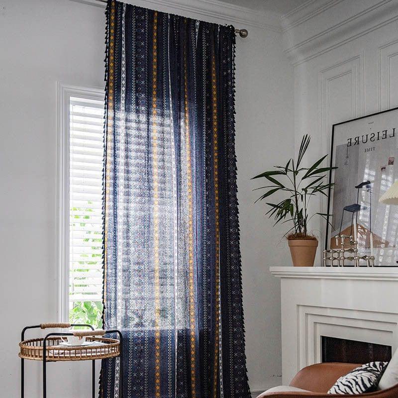 Rideau décoratif à motifs géométriques suspendu dans un salon moderne, apportant une touche élégante et colorée à l'intérieur. La fenêtre laisse entrer une douce lumière naturelle, illuminant subtilement la pièce. Parfait pour ajouter du style et de la chaleur à n'importe quel espace de vie.