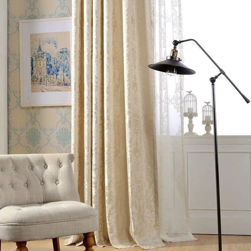 Rideaux élégants beige dans un salon lumineux avec fauteuil confortable et lampe moderne. Décor chaleureux avec tableau artistique et cages décoratives. Ambiance raffinée idéale pour un intérieur chic.