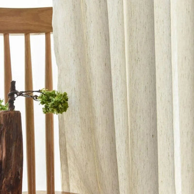 Chaises en bois élégantes avec rideaux légers pour une ambiance naturelle et apaisante dans le salon. Décoration sobre intégrant un vase original, idéal pour un intérieur moderne et chaleureux.