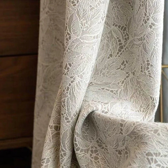Rideau élégant en dentelle beige avec motif floral, idéal pour apporter une touche de sophistication et d'intimité à votre salon ou chambre. Tissu léger offrant une diffusion subtile de la lumière naturelle.