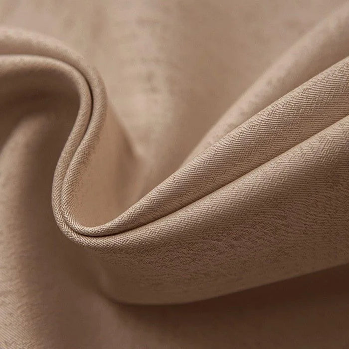 Texture élégante d'un tissu beige en gros plan, révélant un motif subtil et raffiné. Parfait pour la décoration intérieure ou la confection de vêtements, ce tissu offre une finition luxueuse et sophistiquée. Idéal pour ajouter une touche de classe et de confort à tout espace.