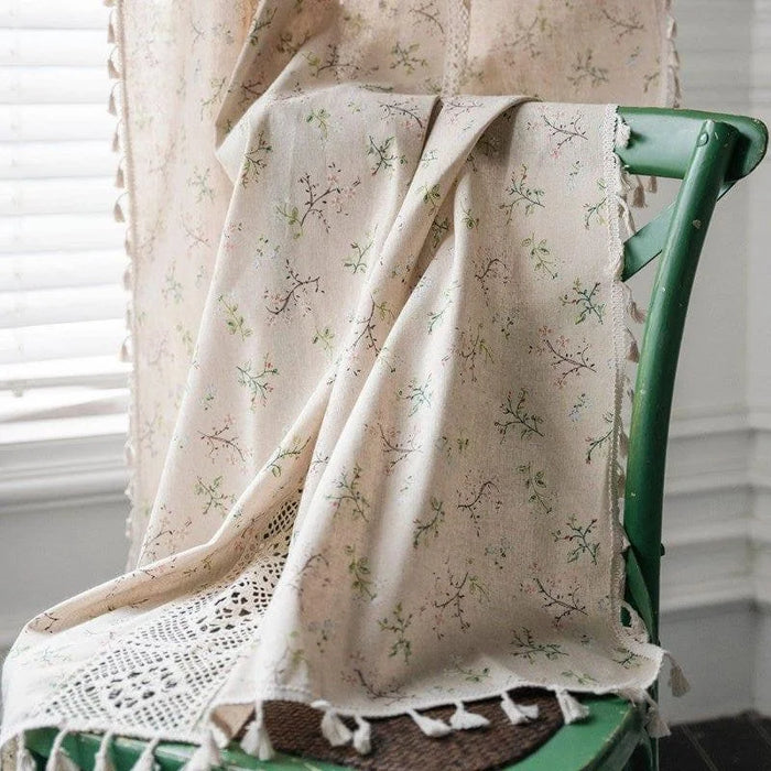 Tissu décoratif à motifs floraux délicats idéal pour une ambiance vintage, drapé sur une chaise verte. Décoration intérieure raffinée, ajoutant une touche naturelle et élégante à votre espace de vie. Style champêtre chic.