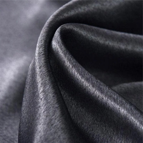 Tissu noir élégant avec texture brillante et ondulée, idéal pour la confection de vêtements haute couture, décoration intérieure luxueuse et accessoires de mode sophistiqués.
