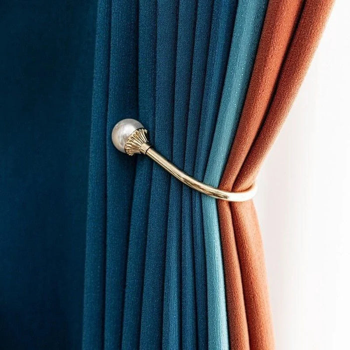 Attache embrasse rideau bleu et orange avec un support doré, idéale pour ajouter une touche élégante et classique à votre décoration intérieure. Ce produit permet de maintenir les rideaux en place tout en ajoutant un élément décoratif sophistiqué à la pièce. Accessoire parfait pour les amateurs de design d'intérieur recherchant une finition soignée et stylée.