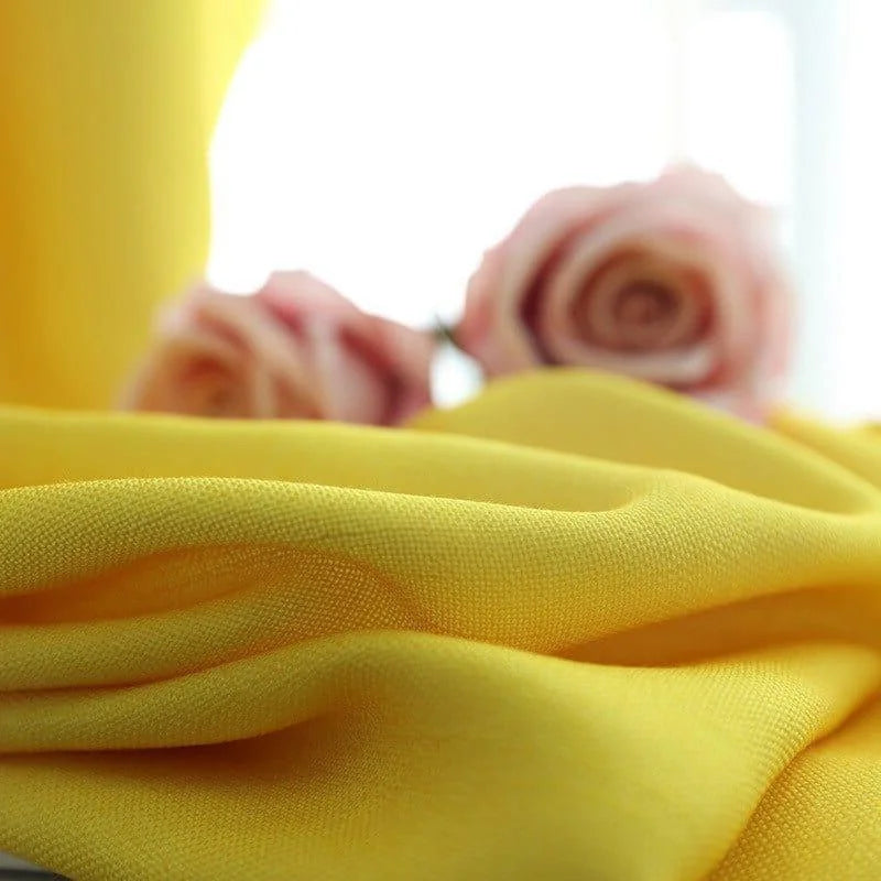 Tissu jaune vif, élégant et doux, parfait pour la décoration intérieure ou la confection de vêtements. Mettez en valeur votre espace avec cette teinte lumineuse et ajoutez une touche de chaleur et de style. Au second plan, des roses pastel ajoutent une touche florale et romantique à l'image.