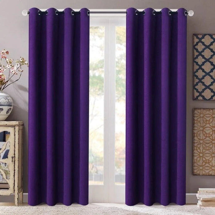 Rideaux opaques violet foncé suspendus à une tringle métal au-dessus d'une grande fenêtre, ajoutant une touche de couleur élégante à la pièce. Décoration moderne avec des éléments contrastants sur les murs. Solution décorative idéale pour salon ou chambre, offrant intimité et design.
