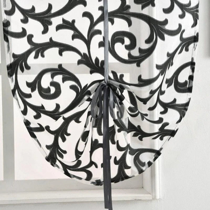 Rideau décoratif avec motif baroque noir sur fond blanc, idéal pour ajouter une touche élégante et moderne à votre intérieur. Ce store à nouer offre une solution pratique et esthétique pour embellir vos fenêtres tout en réglant la luminosité. Parfait pour les salons, chambres ou espaces de travail. Découvrez ce modèle raffiné qui s'intègre harmonieusement dans une variété de décorations d'intérieur.